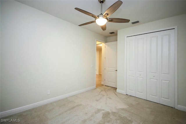 unfurnished bedroom with baseboards, carpet, a closet, and a ceiling fan