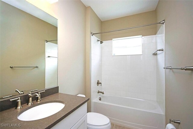bathroom featuring toilet, shower / bath combination, and vanity