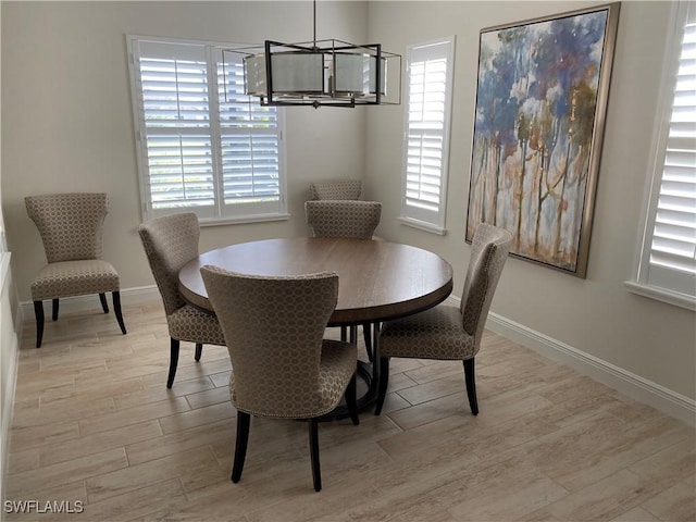 dining area with light wood-style flooring, plenty of natural light, and a chandelier