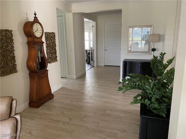 corridor featuring healthy amount of natural light, ornamental molding, wood tiled floors, and baseboards