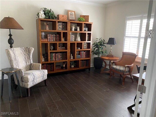living area with ornamental molding and dark wood-style flooring