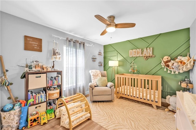 11741 Red Hibiscus Dr, Bonita Springs, FL 34135 - bedroom with ceiling fan, a nursery area, and wood finished floors