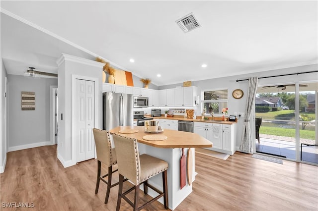 11741 Red Hibiscus Dr, Bonita Springs, FL 34135 - kitchen with visible vents, a kitchen breakfast bar, crown molding, and appliances with stainless steel finishes