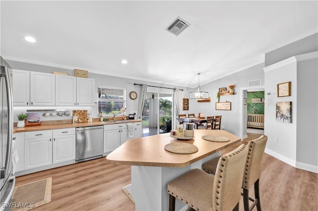 11741 Red Hibiscus Dr, Bonita Springs, FL 34135 - kitchen featuring a kitchen breakfast bar, ornamental molding, white cabinets, visible vents, and stainless steel dishwasher