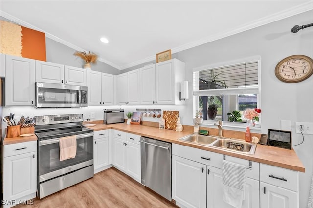 11741 Red Hibiscus Dr, Bonita Springs, FL 34135 - kitchen with crown molding, white cabinets, stainless steel appliances, light wood finished floors, and a sink