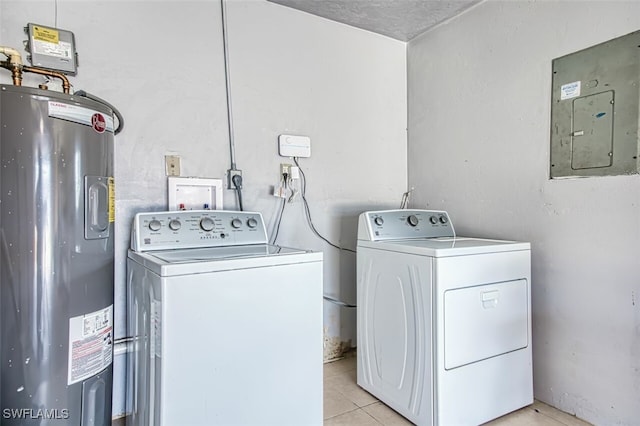 clothes washing area featuring electric water heater, separate washer and dryer, electric panel, light tile patterned floors, and laundry area