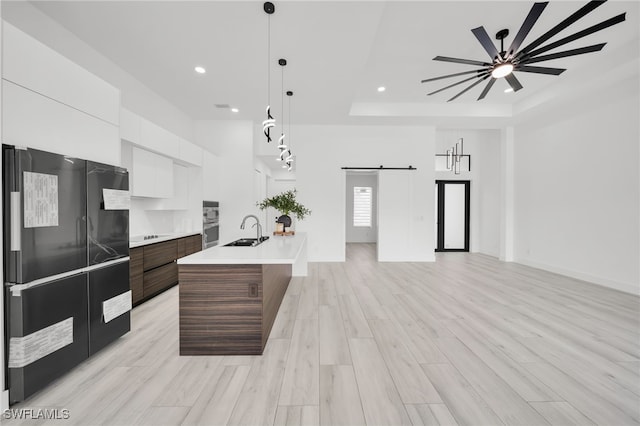 2138 SW 3rd Ave, Cape Coral, FL 33991 - kitchen with black fridge, modern cabinets, a barn door, white cabinets, and recessed lighting