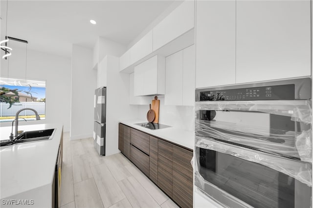 2138 SW 3rd Ave, Cape Coral, FL 33991 - kitchen featuring modern cabinets, white cabinets, black electric stovetop, light countertops, and recessed lighting