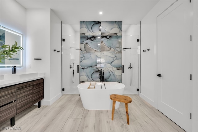 2138 SW 3rd Ave, Cape Coral, FL 33991 - bathroom featuring vanity, a freestanding tub, a stall shower, and wood finished floors