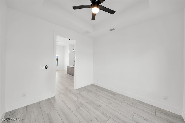 2138 SW 3rd Ave, Cape Coral, FL 33991 - unfurnished room featuring a tray ceiling, ceiling fan, and light wood finished floors