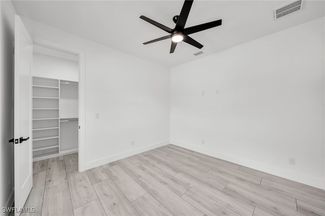 2138 SW 3rd Ave, Cape Coral, FL 33991 - unfurnished bedroom featuring wood finished floors, a spacious closet, a closet, and ceiling fan