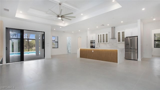 2343 Oil Well Rd, Naples, FL 34120 - kitchen with visible vents, a raised ceiling, wall chimney range hood, open floor plan, and appliances with stainless steel finishes