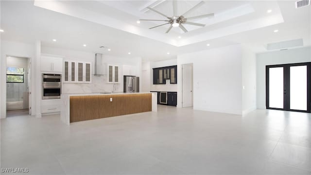 2343 Oil Well Rd, Naples, FL 34120 - unfurnished living room with visible vents, a ceiling fan, a tray ceiling, recessed lighting, and french doors