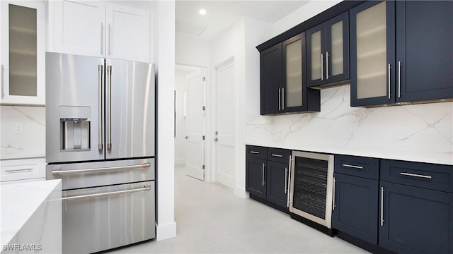 2343 Oil Well Rd, Naples, FL 34120 - kitchen featuring stainless steel fridge with ice dispenser, backsplash, beverage cooler, and light stone countertops