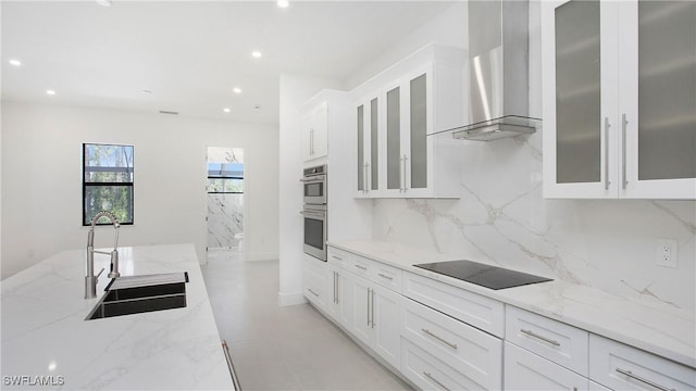 2343 Oil Well Rd, Naples, FL 34120 - kitchen featuring tasteful backsplash, black electric cooktop, a sink, wall chimney range hood, and white cabinetry