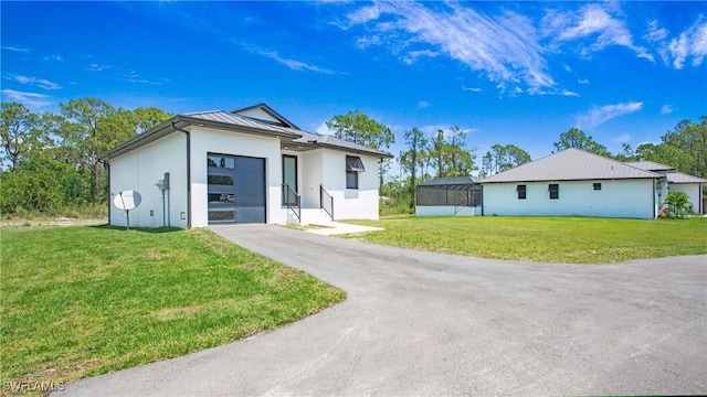 2343 Oil Well Rd, Naples, FL 34120 - ranch-style home featuring a standing seam roof, a garage, stucco siding, metal roof, and concrete driveway