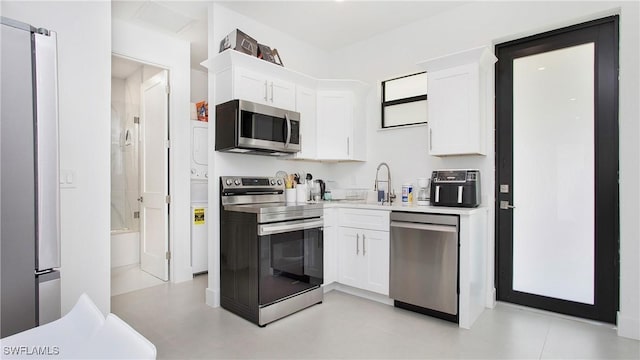 2343 Oil Well Rd, Naples, FL 34120 - kitchen with stainless steel appliances, light countertops, white cabinetry, and a sink