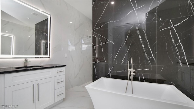 2343 Oil Well Rd, Naples, FL 34120 - bathroom featuring a freestanding bath, vanity, marble finish floor, and tile walls