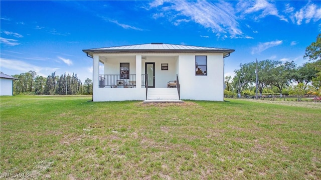2343 Oil Well Rd, Naples, FL 34120 - view of front of house with stucco siding, a front lawn, a porch, a standing seam roof, and metal roof