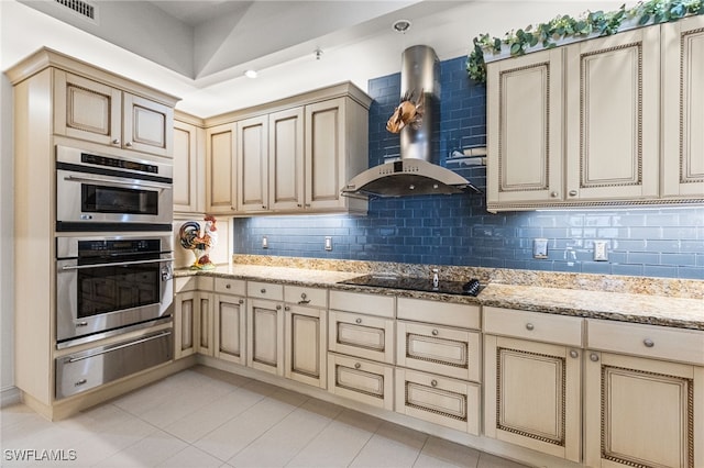 14270 Royal Harbour Ct Unit 323, Fort Myers, FL 33908 - kitchen with a warming drawer, cream cabinetry, black electric cooktop, and wall chimney range hood