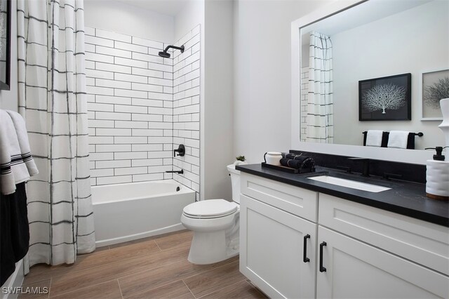 bathroom with toilet, shower / bath combo with shower curtain, wood finished floors, and vanity