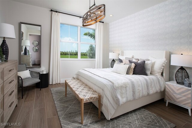 bedroom with recessed lighting, baseboards, dark wood-style flooring, and a notable chandelier