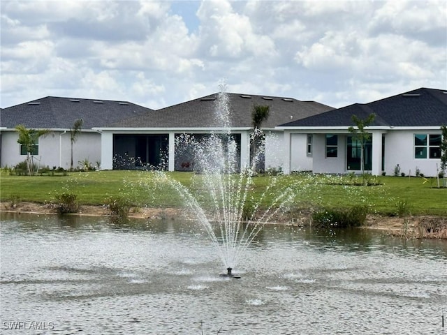 16325 Preservation Blvd, Punta Gorda, FL 33982 - rear view of house with a water view, stucco siding, a lawn, and driveway