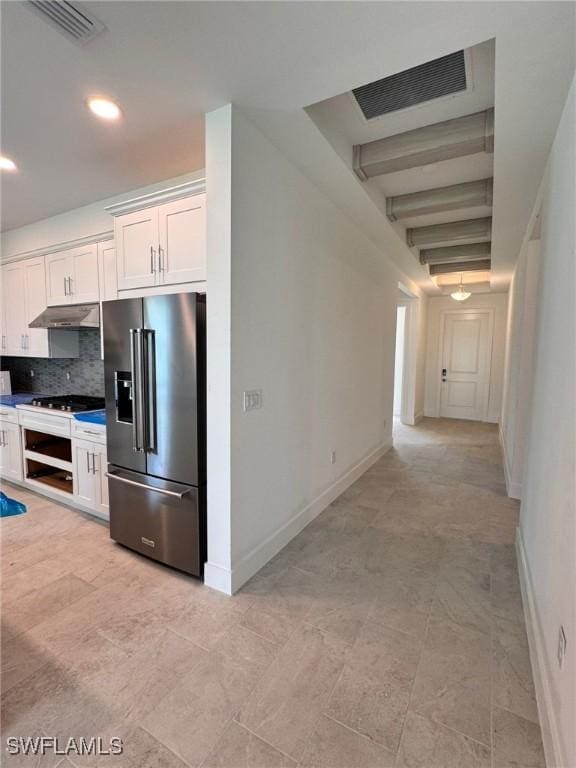 16325 Preservation Blvd, Punta Gorda, FL 33982 - kitchen with high end refrigerator, under cabinet range hood, tasteful backsplash, white cabinets, and baseboards