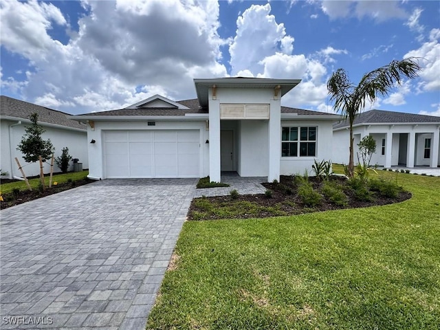 16325 Preservation Blvd, Punta Gorda, FL 33982 - view of front of property featuring stucco siding, decorative driveway, a front lawn, and an attached garage