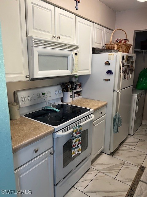 kitchen featuring washer / clothes dryer, white cabinetry, marble finish floor, and white appliances