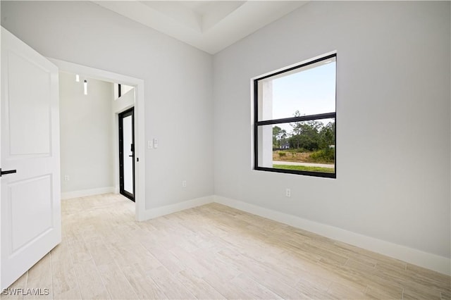 empty room with baseboards and light wood finished floors