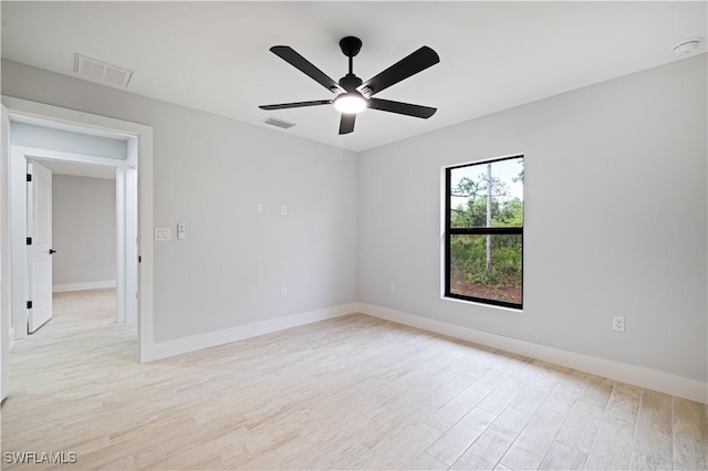 empty room featuring light wood-type flooring, baseboards, a ceiling fan, and visible vents