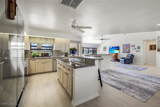 2556 SW 28th Pl, Cape Coral, FL 33914 - kitchen with a kitchen breakfast bar, ceiling fan, stainless steel dishwasher, light wood-type flooring, and a sink