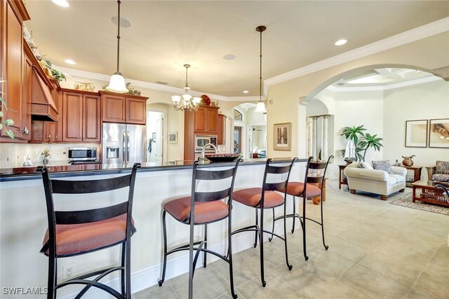 4536 SW 12th Pl, Cape Coral, FL 33914 - kitchen featuring arched walkways, dark countertops, a kitchen bar, and appliances with stainless steel finishes
