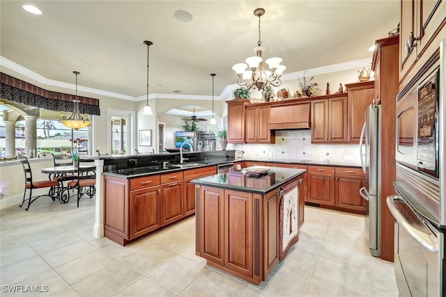 4536 SW 12th Pl, Cape Coral, FL 33914 - kitchen featuring brown cabinetry, a peninsula, a chandelier, dark countertops, and stainless steel appliances