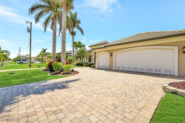 4536 SW 12th Pl, Cape Coral, FL 33914 - mediterranean / spanish-style house with stucco siding, decorative driveway, a tile roof, a front lawn, and an attached garage