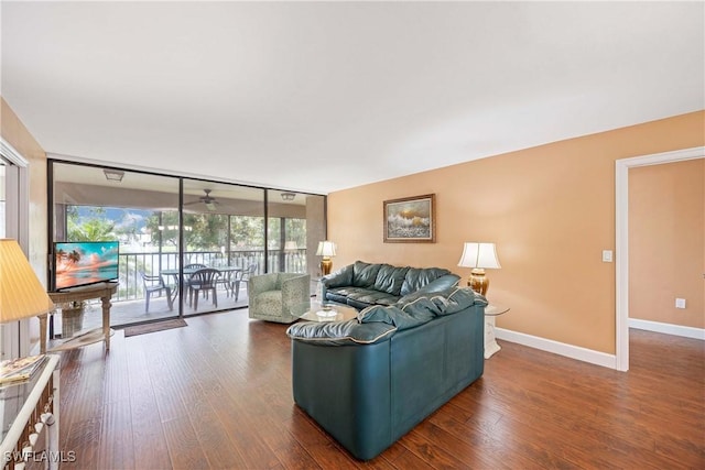 living area with wood finished floors, floor to ceiling windows, and baseboards