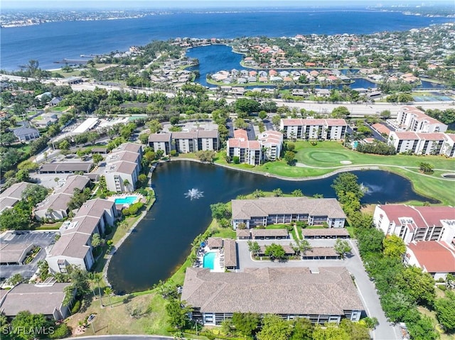 drone / aerial view with a water view, golf course view, and a residential view