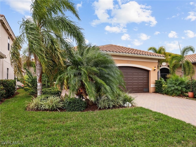 11552 Riverstone Ln, Fort Myers, FL 33913 - mediterranean / spanish house with decorative driveway, a tiled roof, an attached garage, stucco siding, and a front yard