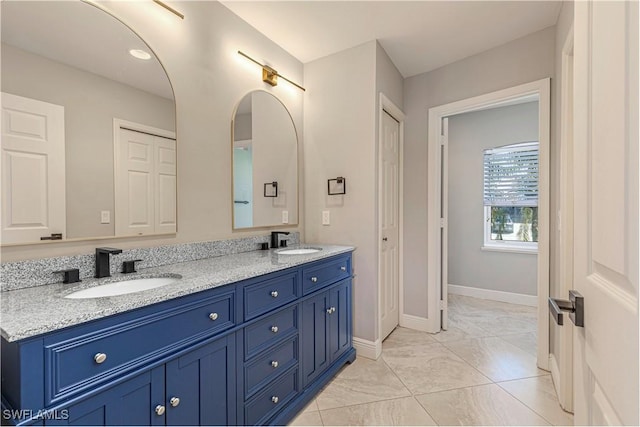 1633 Barbarosa Ct, Marco Island, FL 34145 - full bath with marble finish floor, double vanity, a sink, and baseboards