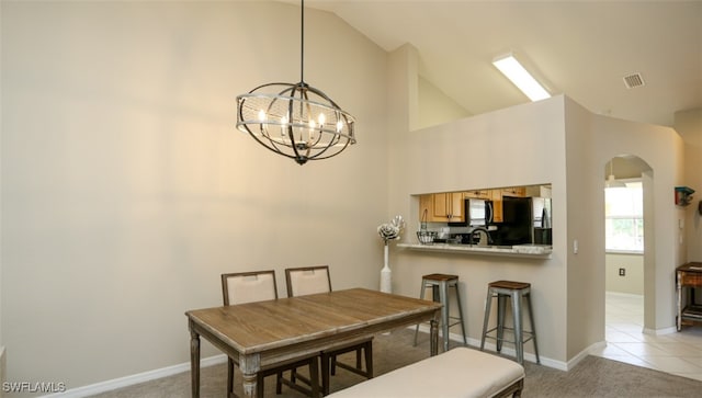 6645 Huntington Lakes Cir Unit 201, Naples, FL 34119 - dining room featuring high vaulted ceiling, arched walkways, an inviting chandelier, baseboards, and visible vents