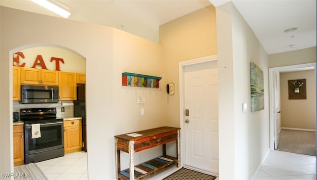 6645 Huntington Lakes Cir Unit 201, Naples, FL 34119 - kitchen featuring light tile patterned floors, light countertops, backsplash, and appliances with stainless steel finishes