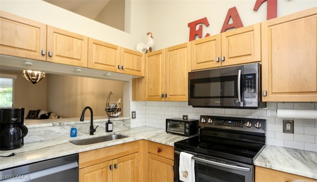 6645 Huntington Lakes Cir Unit 201, Naples, FL 34119 - kitchen with tasteful backsplash, a sink, light brown cabinetry, appliances with stainless steel finishes, and light stone countertops