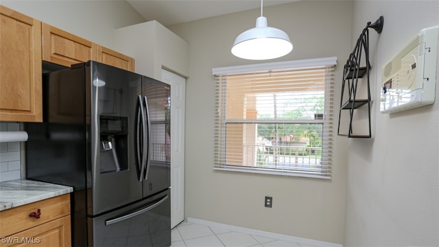 6645 Huntington Lakes Cir Unit 201, Naples, FL 34119 - kitchen with light stone counters, light tile patterned flooring, baseboards, decorative backsplash, and black fridge