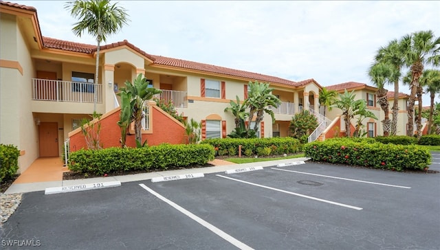 6645 Huntington Lakes Cir Unit 201, Naples, FL 34119 - view of property with stairway and uncovered parking
