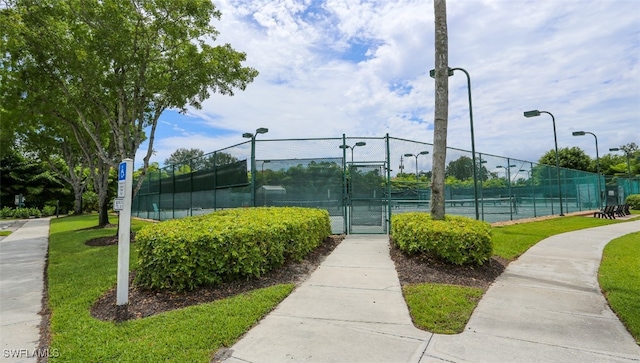 6645 Huntington Lakes Cir Unit 201, Naples, FL 34119 - view of tennis court featuring a gate, a yard, and fence