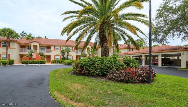 6645 Huntington Lakes Cir Unit 201, Naples, FL 34119 - view of front of home with a tiled roof, parking, and stucco siding