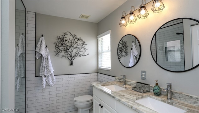 6645 Huntington Lakes Cir Unit 201, Naples, FL 34119 - bathroom featuring double vanity, visible vents, toilet, and a sink