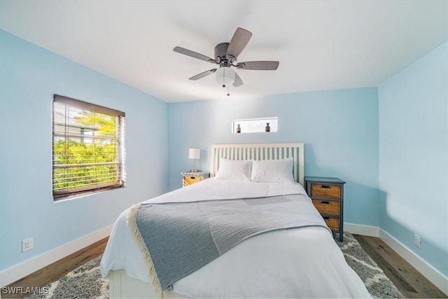 bedroom with baseboards, ceiling fan, and wood finished floors