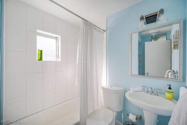 bathroom with shower / tub combo, a sink, and toilet